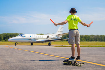 ground crew guiding plane