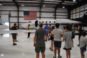 Shoreline Aviation Line Services Technician Callie Almeder talks to Marshfield Scouts about the Citation jets in the hangar. 