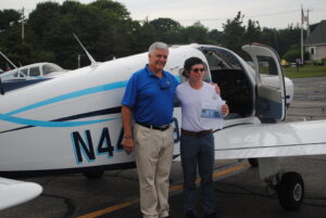 Flight instructor Roger Means proudly poses with his teenage student Tim Stiles