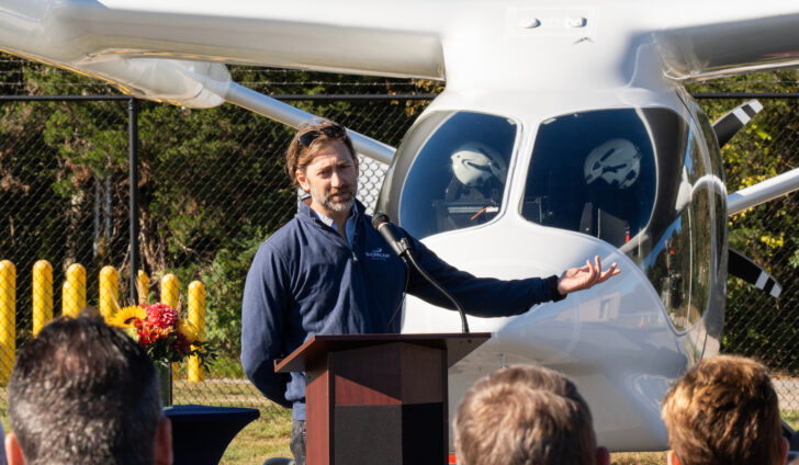 Geoff Douglass brings attention to BETA Technologies’ all electric aircraft ALIA during his remarks. Photo courtesy of BETA Technologies