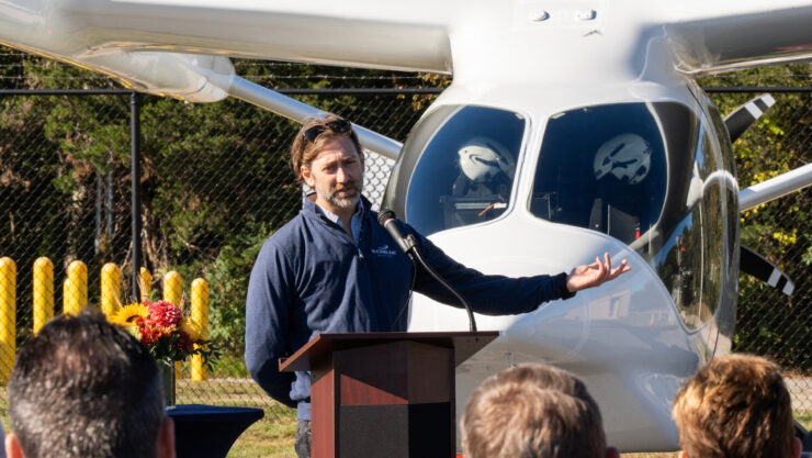 Geoff Douglass brings attention to BETA Technologies’ all electric aircraft ALIA during his remarks. Photo courtesy of BETA Technologies