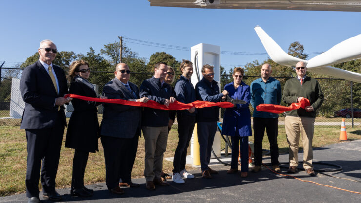 Dignitaries cut a ceremonial ribbon celebrating the commissioning of Shoreline Aviation’s new BETA Technologies-designed electric aircraft charging station, at Marshfield Municipal Airport.