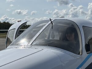 Flight student Una Delabruere smiles through the windshield of the Piper Warrior she just landed. 