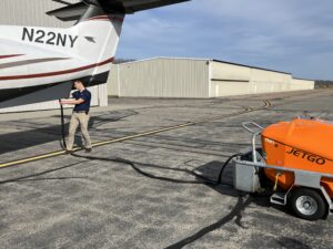 Assistant Airport Manager Ben Garman plugs the Jetgo ground power unit into the Pilatus. 