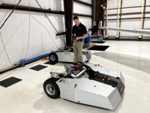 Assistant Airport Manager Ben Garman powers up Shoreline’s electric tug to prepare it to move the fleet’s Pilatus PC-12NG from its hangar. 