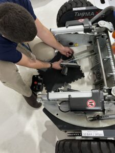 Assistant Airport Manager Ben Garman adjusts the arms of Shoreline’s electric tug to prepare it to move the fleet’s Pilatus PC-12NG from its hangar. 