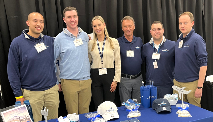 Logan Timpany, left, Patrick Olson, Erin Mulcahy, Keith Douglass, Evan Cadavieco and Manny Escobar pose at Shoreline Aviation’s MBAA Aviation Day booth.