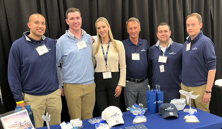 Logan Timpany, left, Patrick Olson, Erin Mulcahy, Keith Douglass, Evan Cadavieco and Manny Escobar pose at Shoreline Aviation’s MBAA Aviation Day booth.