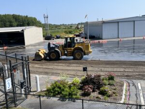 A bulldozer begins plowing up shredded surface material. 