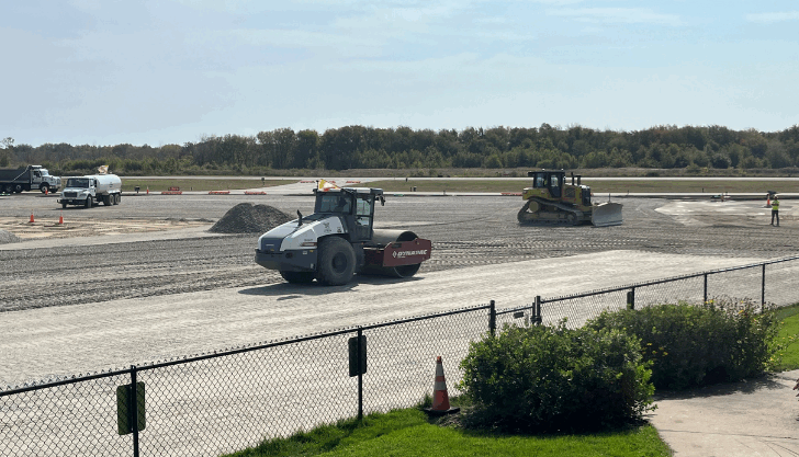 P-209 material is being graded and compacted.