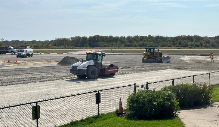 P-209 material is being graded and compacted.