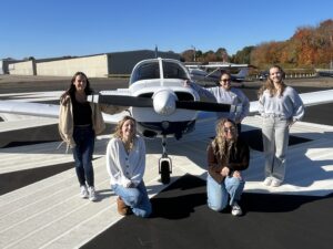 Abby Marinelli, front left, Andrea Hewett, Isabella DiRusso, back left, Helen Lin, and Varvara Karenski have all flown this Piper Warrior trainer.