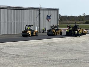Rollers compact the newly poured asphalt. 