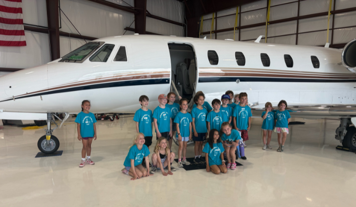 Chandler Elementary School second-graders pose with a Citation jet at Marshfield Airport.